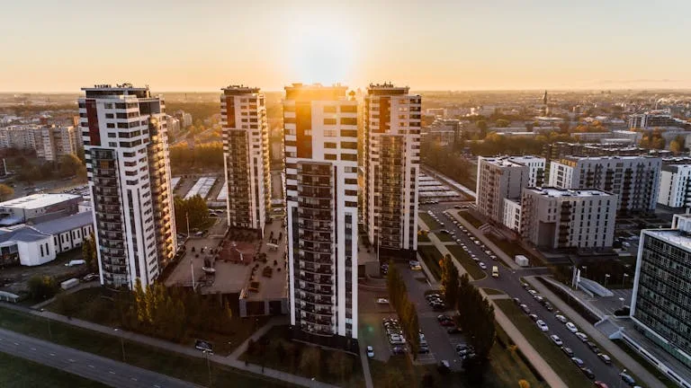 Captivating high-rise buildings silhouetted by a setting sun in a bustling cityscape.